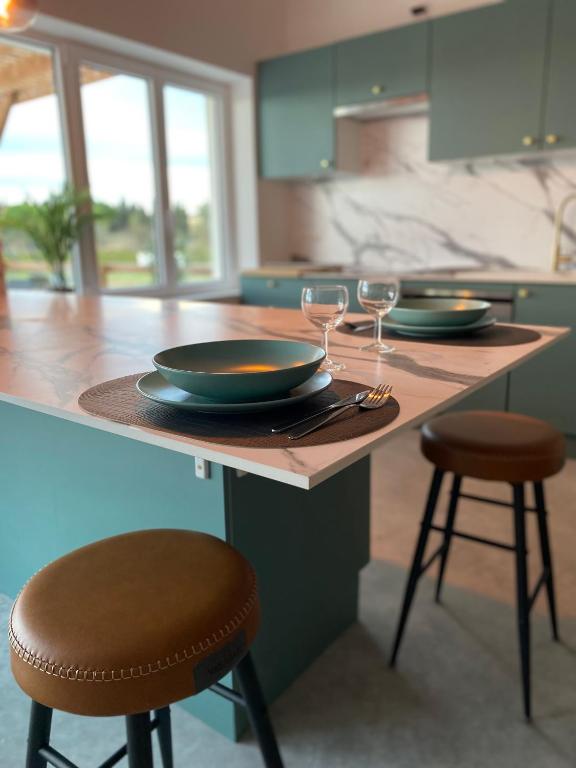 une cuisine avec une table avec des assiettes et des verres à vin dans l'établissement Domaine Font Castel - Gîte Ottignies, à Béziers