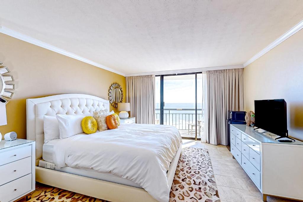 1 dormitorio con 1 cama blanca grande y TV en King Luis - B en Galveston