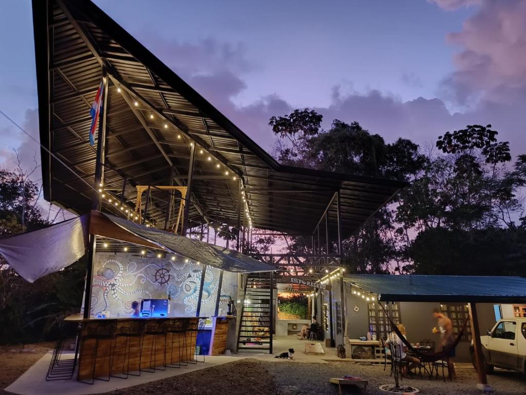 a house with lights on the side of it at Shipwrecked Hostel in Uvita