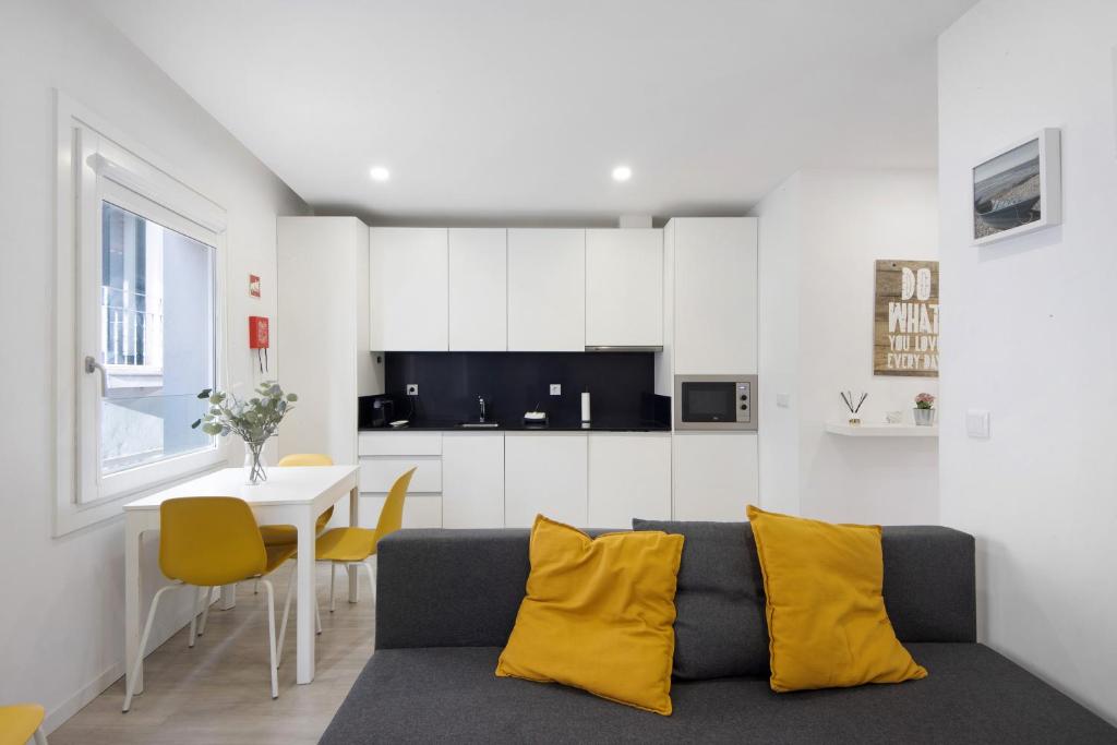uma sala de estar com um sofá e uma mesa com almofadas amarelas em Coração de Aveiro em Aveiro