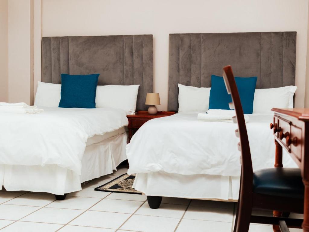 Postel nebo postele na pokoji v ubytování Ngwenya City Hotel