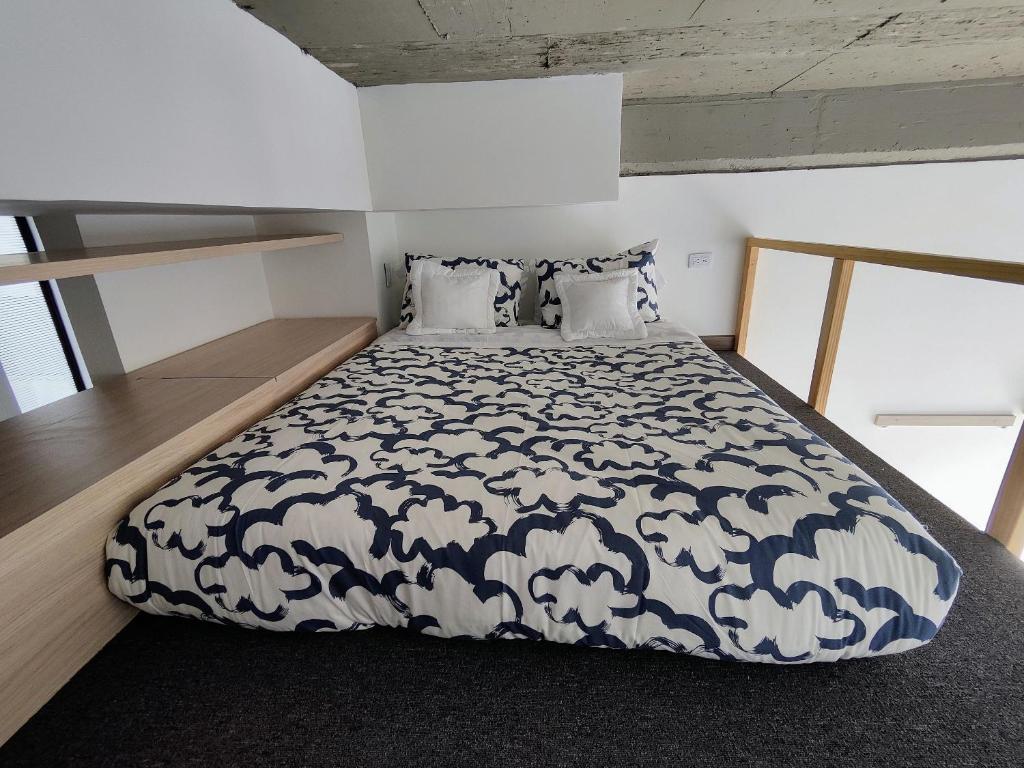 a bedroom with a bed with a black and white comforter at Elegante Loft en Chapinero! 401 in Bogotá