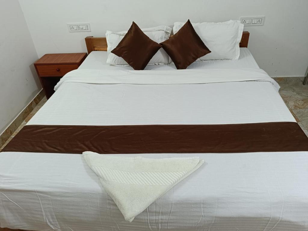 two beds with white sheets and brown pillows at HOTEL ATITHI GRAND in Guwahati