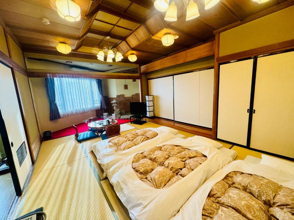 a large room with three beds in it at Fuji Green Hotel in Fuji