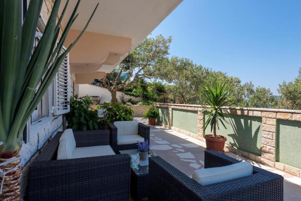 a patio with couches and plants on a building at Relaxing Beach holiday house in Hvar