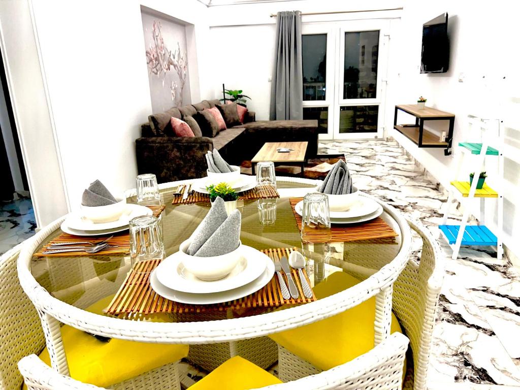 a living room with a glass table and chairs at Luxury Apartment in Alexandria