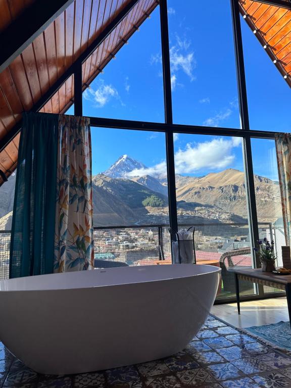 a bath tub in a room with a view of a mountain at Cottage Veranda in Kazbegi