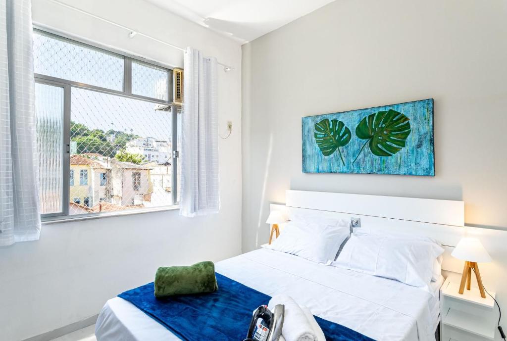 Habitación blanca con cama y ventana en Temporada Santa Tereza - Conforto e Tranquilidade en Río de Janeiro