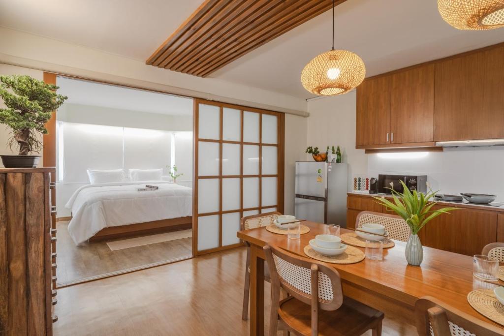 una cucina e un soggiorno con letto e tavolo di Mini Jung Nimmari a Chiang Mai