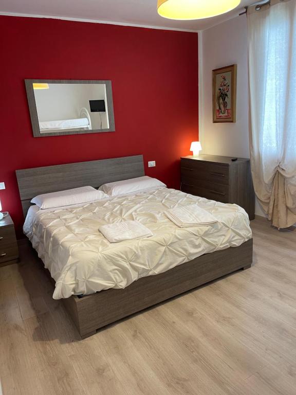 1 dormitorio con 1 cama grande y pared roja en Romantic enchantment with private bathroom, en Venecia