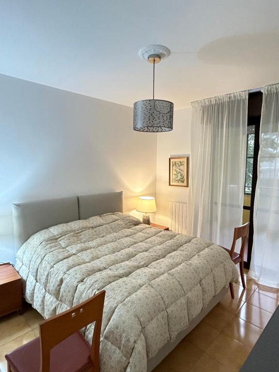 a bedroom with a large bed and two chairs at Casa vacanze 1702, con la camera matrimoniale con il bagno privato e un soggiorno comune in Milan