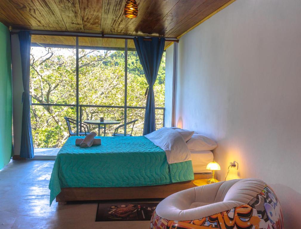 a bedroom with a bed and a large window at Casa Pistacho in Santa Marta