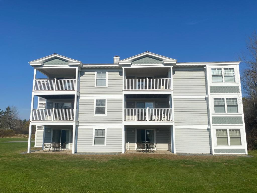 a large apartment building with a lawn in front of it at Acadia Village Resort in Ellsworth