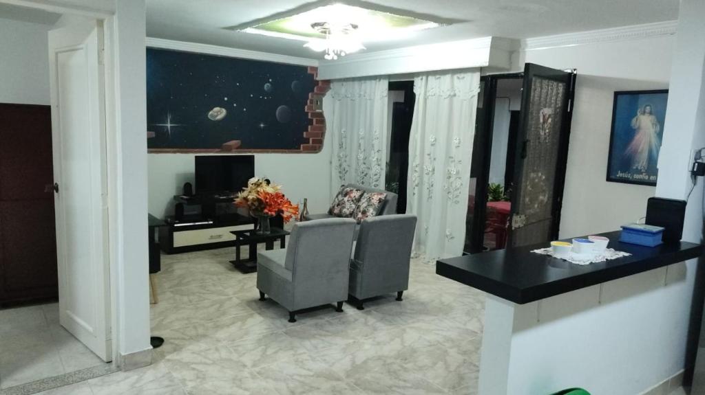 uma sala de estar com duas cadeiras e uma mesa em Apartamento en Ibague em Ibagué