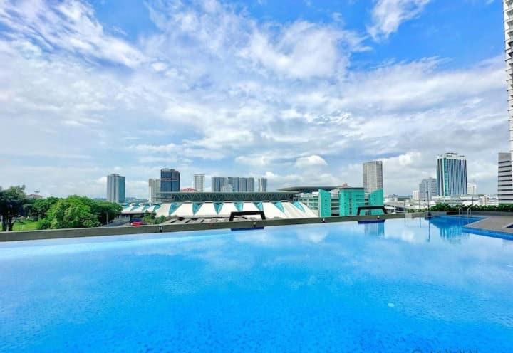 une grande piscine bleue avec une ville en arrière-plan dans l'établissement Bukit Cagar Nearest walk Johor Bahru custom Ciq by YHA, à Johor Bahru