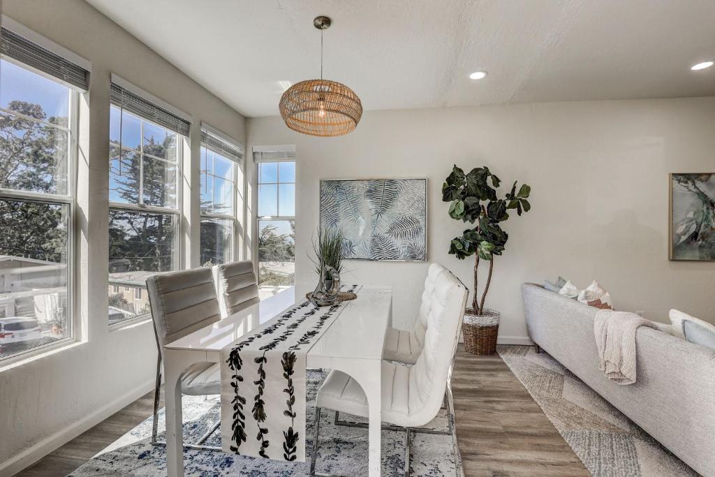 a dining room with a white table and a couch at @ Marbella Lane - Modern 3BR Home w/ Ocean Views in Pacifica
