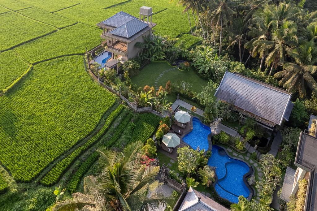 een luchtzicht op een villa met een zwembad bij Gynandha Ubud Cottage in Ubud