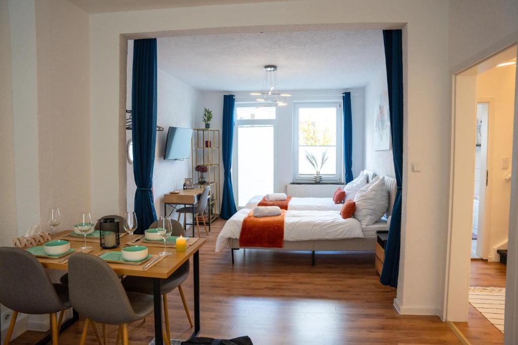 - une chambre avec un lit et une table avec des chaises dans l'établissement Volante Apartment Bremen-Findorff, à Brême