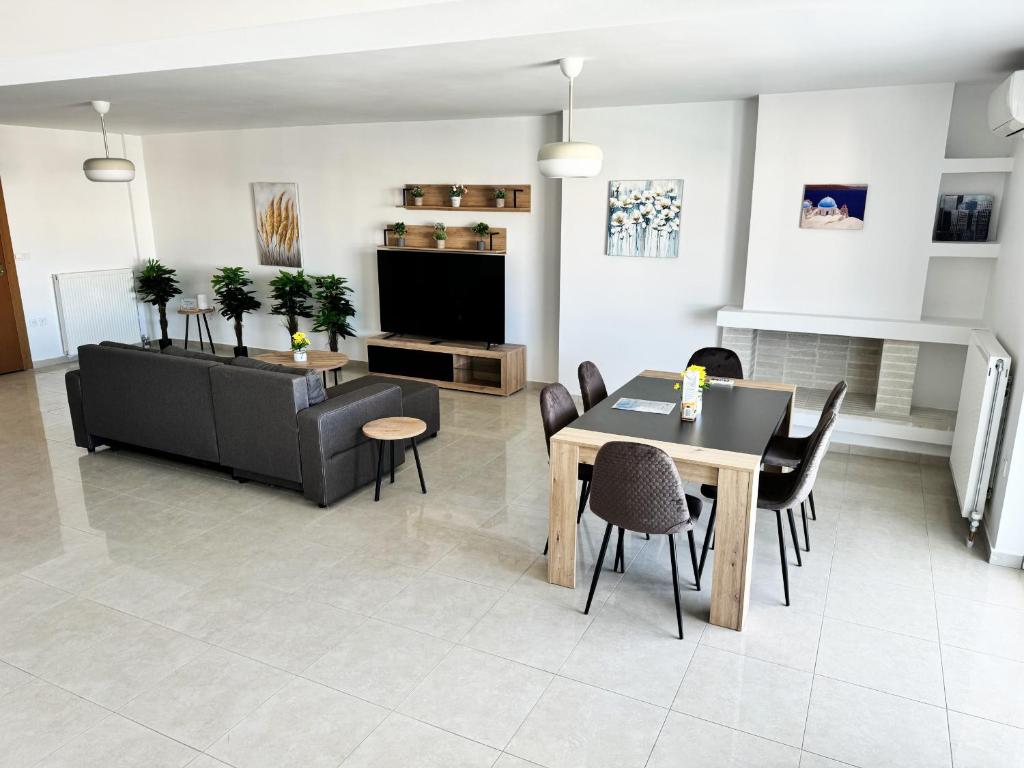 een woonkamer met een tafel en stoelen en een televisie bij Gtrip Nea Smyrni Floor Apartment 7F in Athene