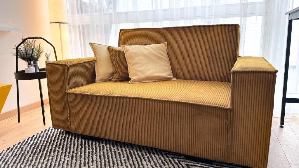 uma cadeira castanha com duas almofadas na sala de estar em Vytauto 80 em Palanga