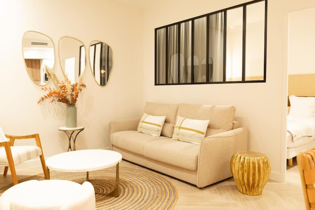 uma sala de estar com um sofá e dois espelhos em NEW Luxury & Cozy Apartment - 6p em Paris