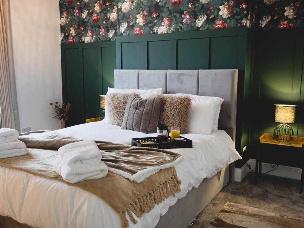 a bedroom with a white bed with a green wall at Station House Haworth in Haworth