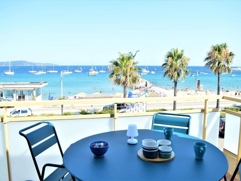 une table bleue avec des chaises et une vue sur la plage dans l'établissement Appartement T2 climatisé avec parking à Cavalaire-sur-Mer - FR-1-226B-72, à Cavalaire-sur-Mer