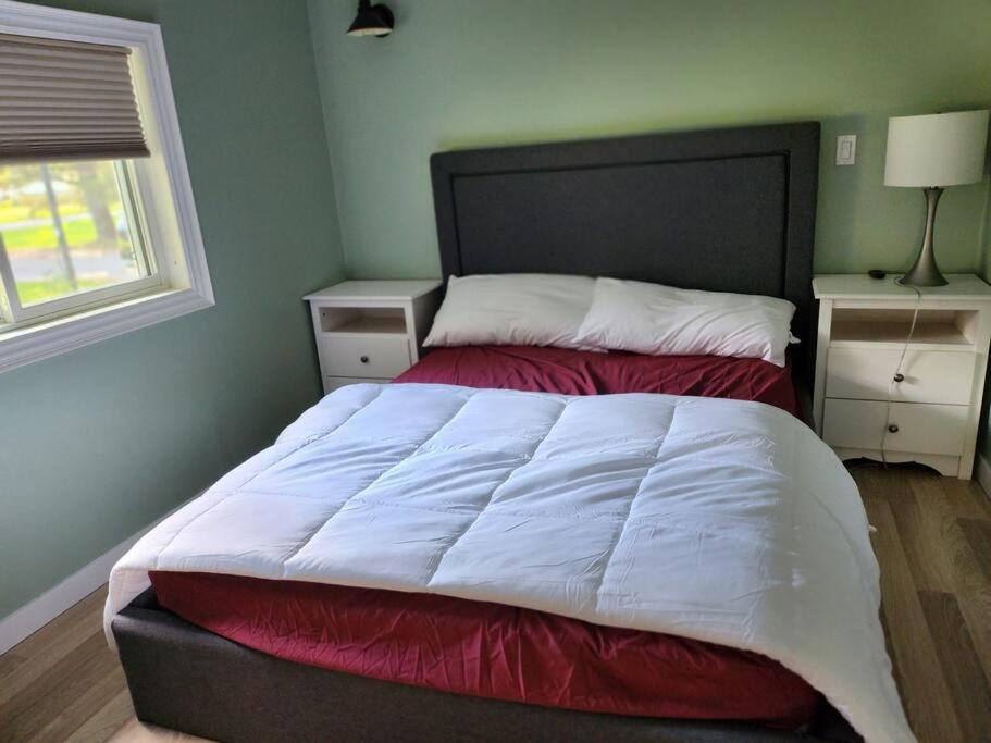 een bed met een rood en wit dekbed in een slaapkamer bij Belle Head River in Kawartha Lakes