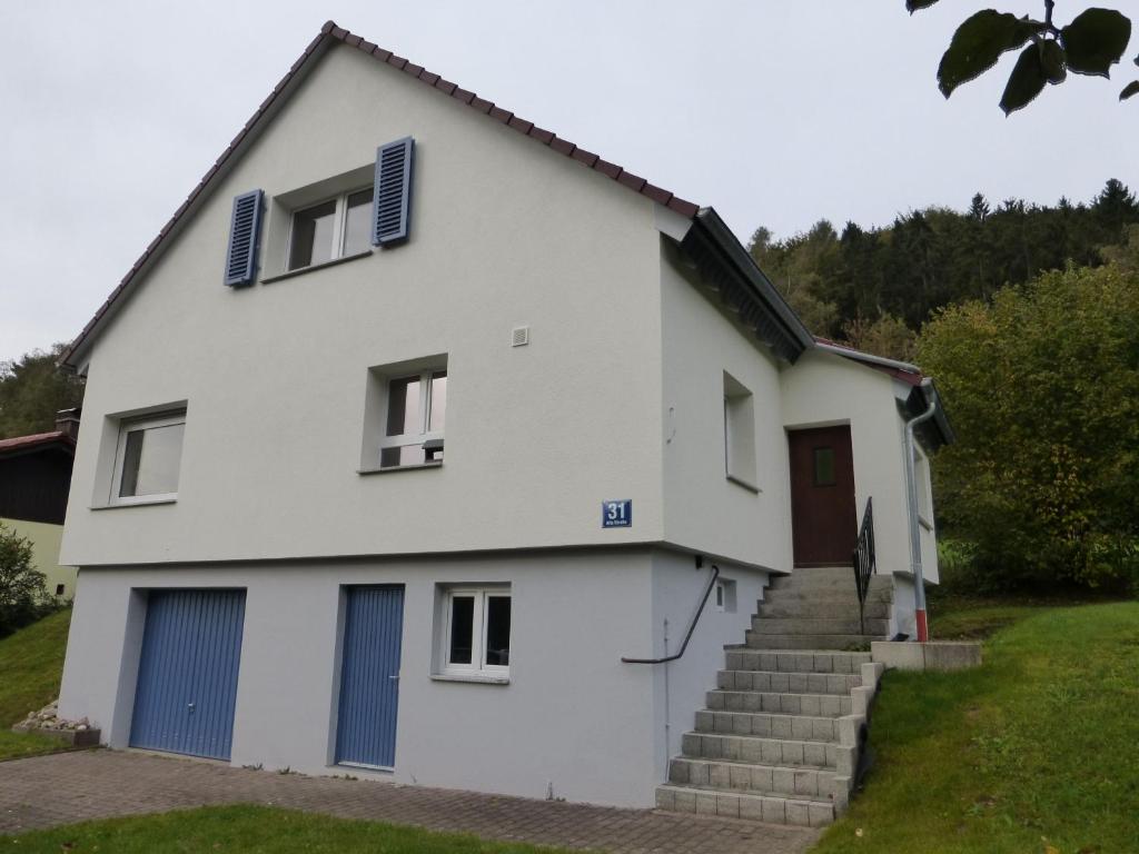 een wit huis met blauwe deuren en trappen bij Ferienhaus Ernas Hygge 