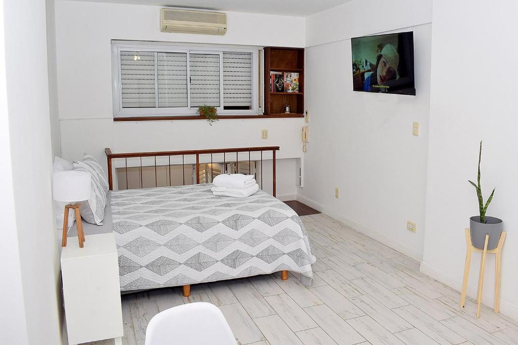 Habitación blanca con cama y ventana en Estudio Petite Arroyo en Buenos Aires