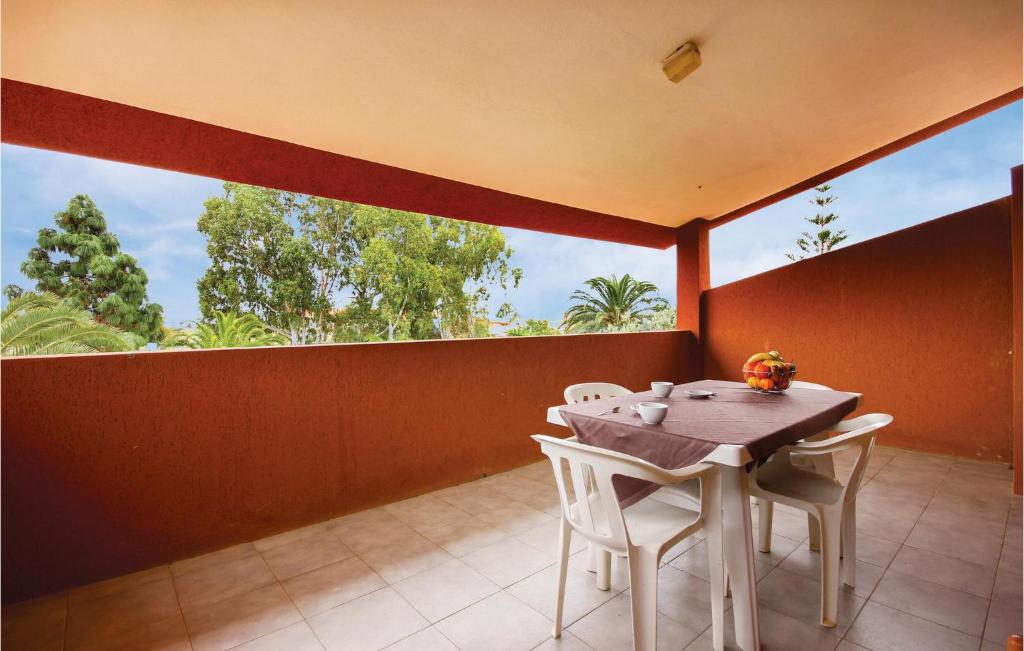 uma sala de jantar com uma mesa e cadeiras numa varanda em 1 Bedroom Gorgeous Apartment In Costa Rei -ca- em Monte Nai