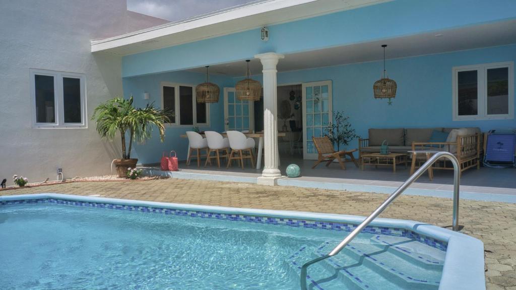 a swimming pool in front of a house at NEW ! Cozy Casa in Oranjestad