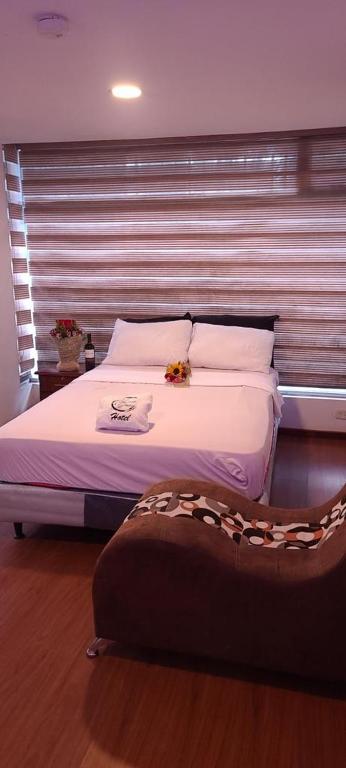 um quarto com uma cama grande e uma janela em Hotel YURA y YANA em Quito