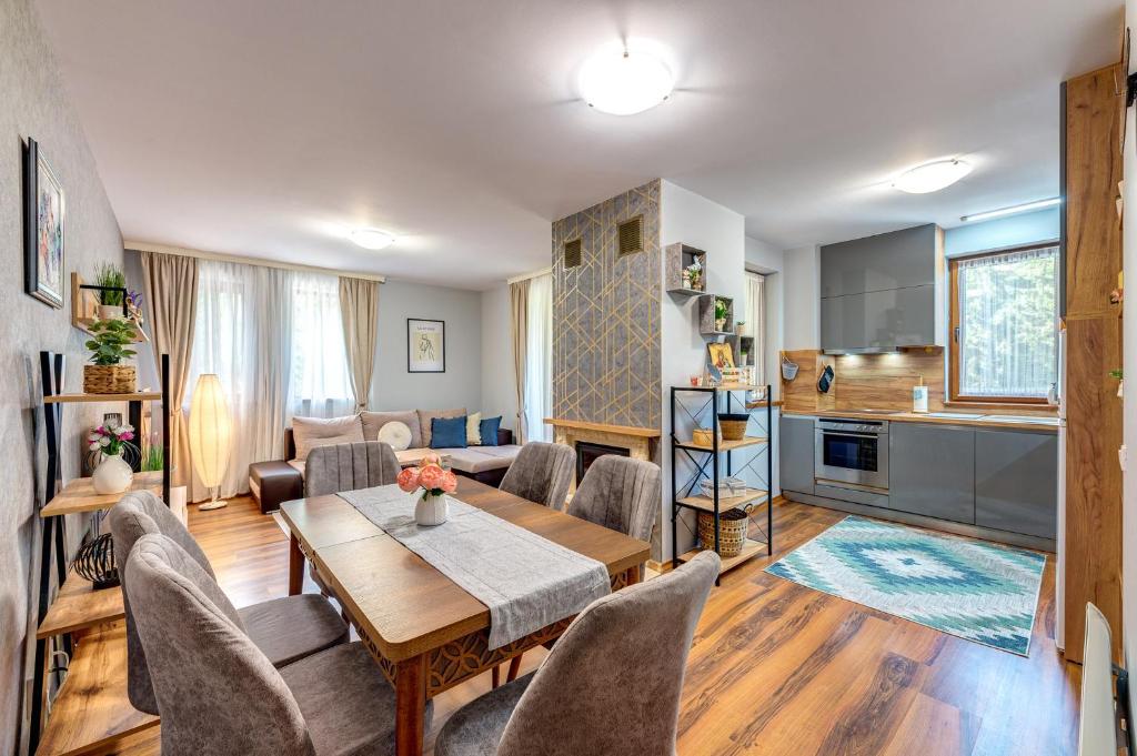 a living room with a table and chairs and a kitchen at Luxury Flat in Grand Resort Pamporovo in Pamporovo
