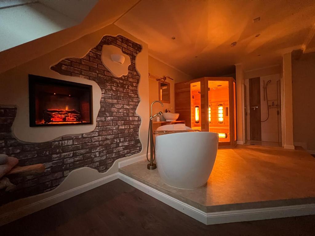 a bathroom with a fireplace and a bath tub at Dagmar 120qm 3 Schlafzimmer Wellness in Olsberg