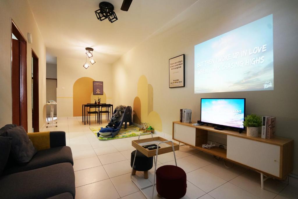 a living room with a flat screen tv on a wall at Desaru beach waterpark Tvbox By Joyfully 22b10 in Desaru