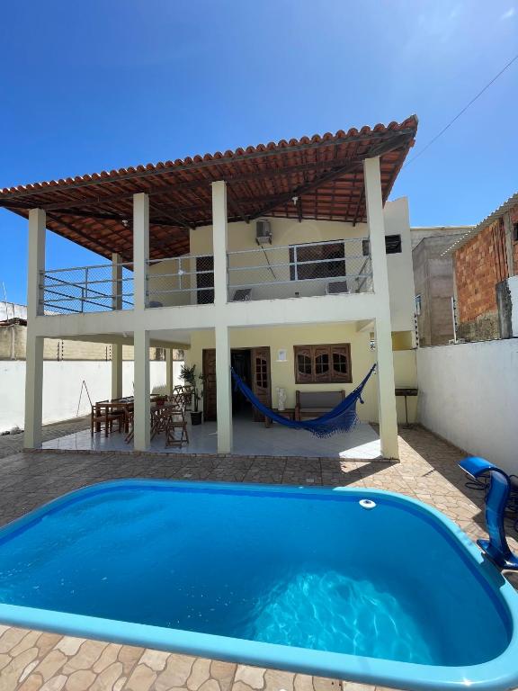 una villa con piscina di fronte a una casa di Pousada Praia do Francês a Praia do Frances