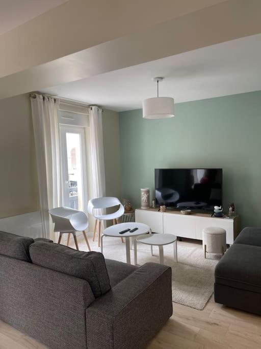 un salon avec un canapé, des chaises et une télévision dans l'établissement Très bel appt en centre ville, à Le Touquet-Paris-Plage
