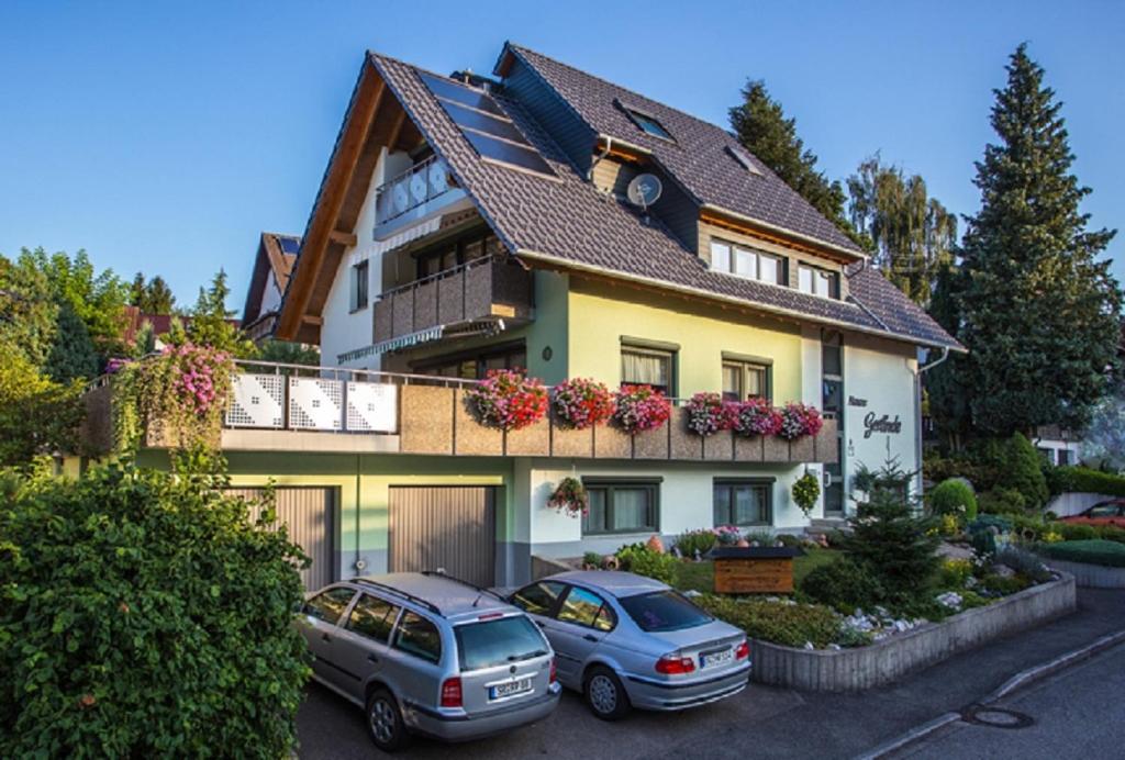 two cars parked in front of a house at Haus Gerlinde in Zell am Harmersbach