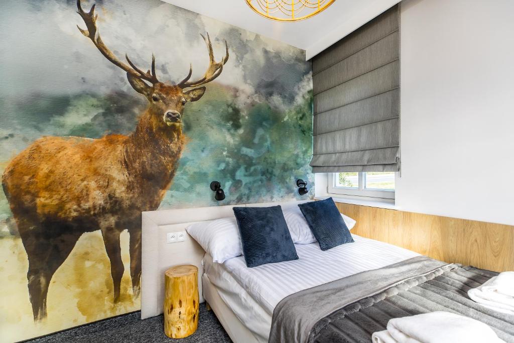 un dormitorio con una pintura de un ciervo en la pared en Bukowina Tatrzańska- apartament Dudek z widokiem na Tatry en Bukowina Tatrzańska