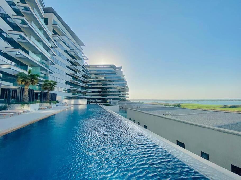 una piscina di fronte a un grande edificio di Furnished & Serviced Studio a Abu Dhabi