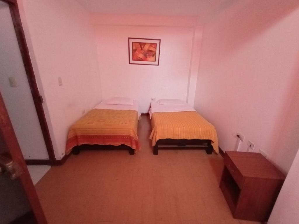 duas camas num pequeno quarto em El copihue em Tacna