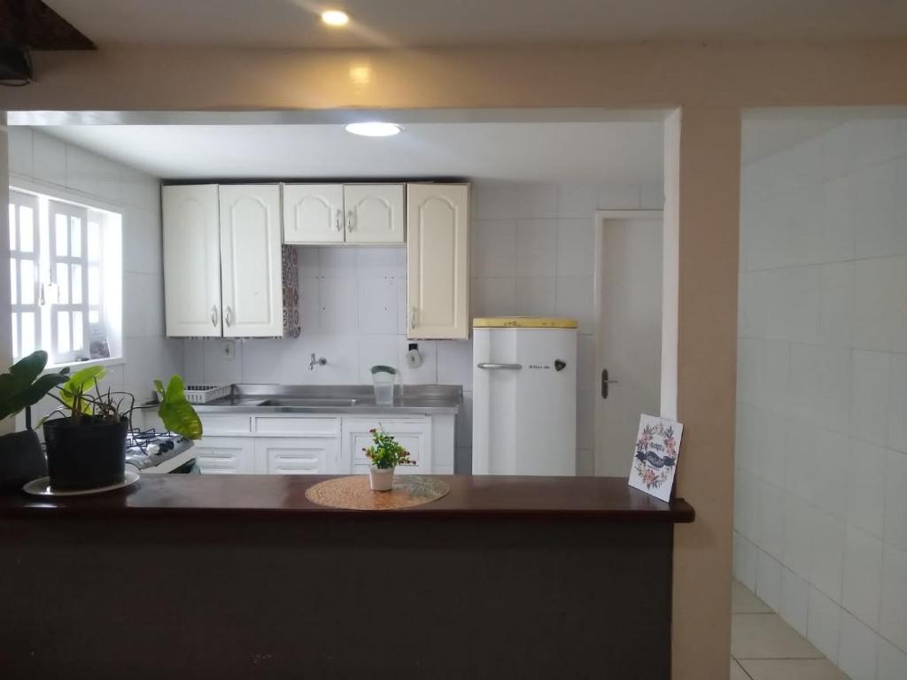 布希奧斯的住宿－Habitación con baño y cocina compartido-Porto da Barra，厨房配有白色橱柜和白色冰箱。