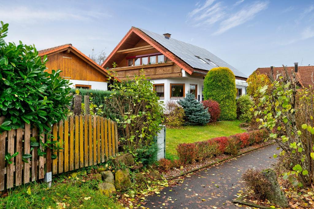 a house with a wooden fence in front of a yard at Haus Felix in Neubulach
