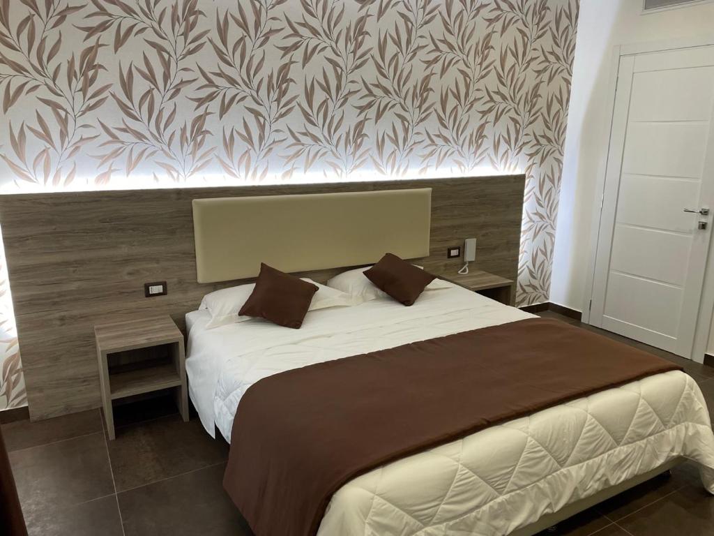 a bedroom with a large bed with a wall at La Suite in Villa in Cittanova