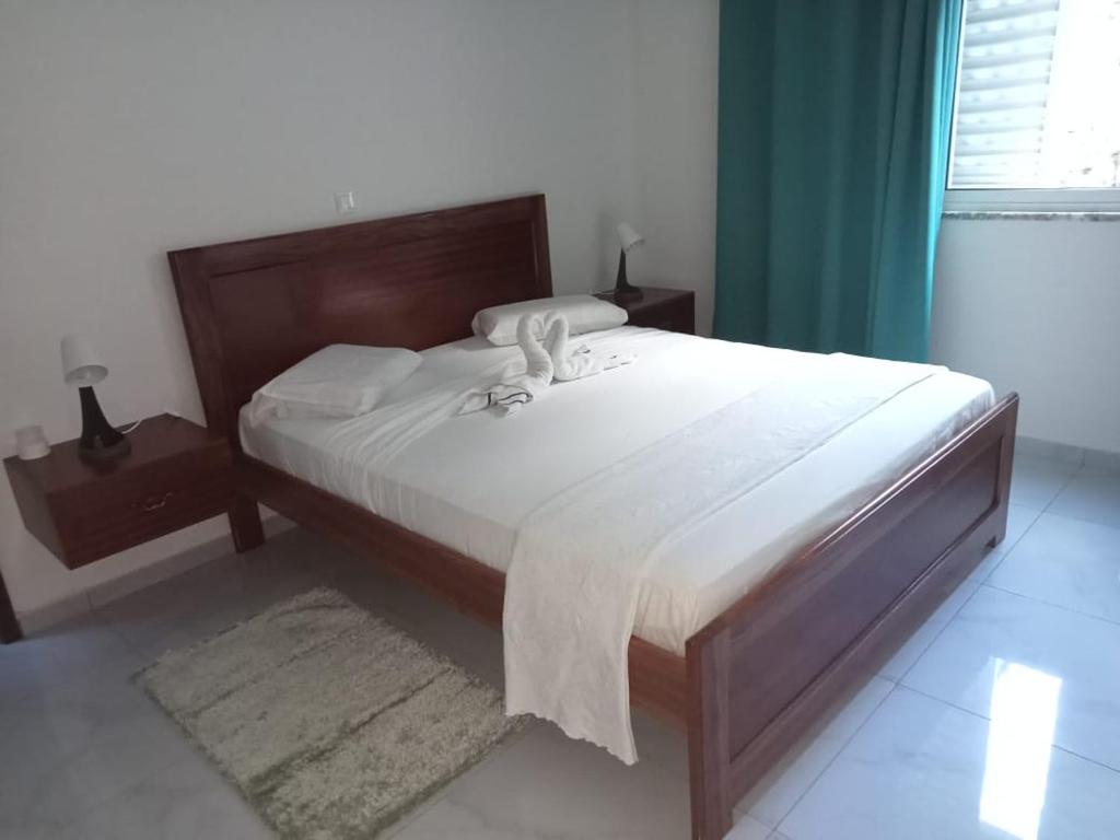 um quarto com uma cama grande e lençóis brancos em Bentub home em Ribeira Grande