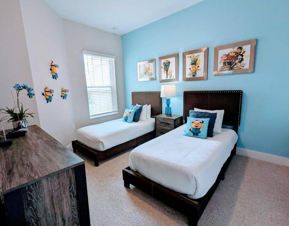 a bedroom with two beds and blue walls at Gorgeous 4 Suites DREAM Villa 5 min to Disney in Orlando