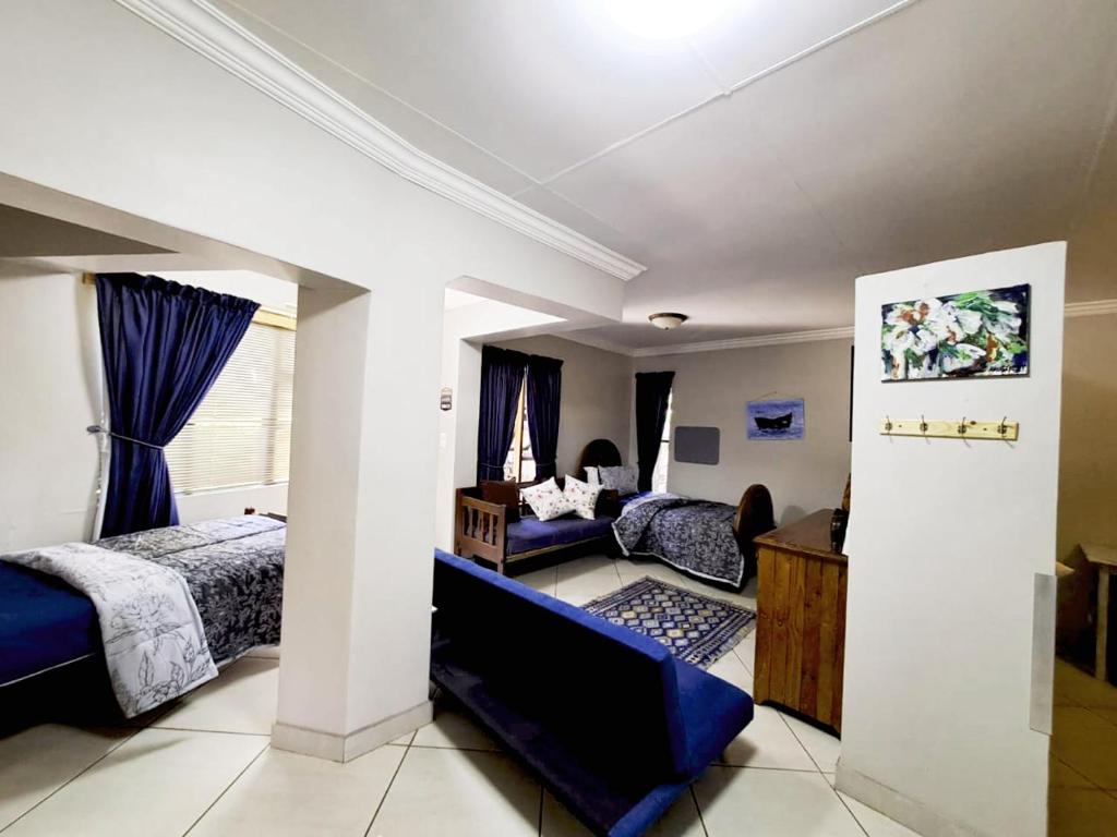 a bedroom with a bed and a living room at THE POT AIRBNB, FAERIE GLEN, PRETORIA EAST in Pretoria