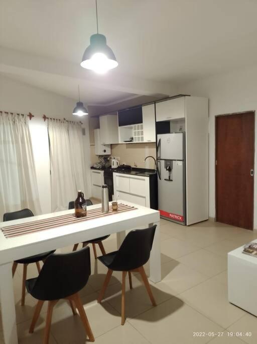 eine Küche mit einem Tisch und Stühlen sowie einem Kühlschrank in der Unterkunft DEPARTAMENTO 2 DOR. ZONA PARQUE CON JACUZZI in Paraná