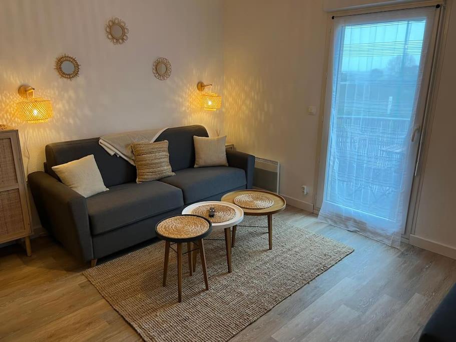 ein Wohnzimmer mit einem Sofa und 2 Tischen in der Unterkunft Studio confortable aux portes de Bordeaux et Médoc in Ludon-Médoc